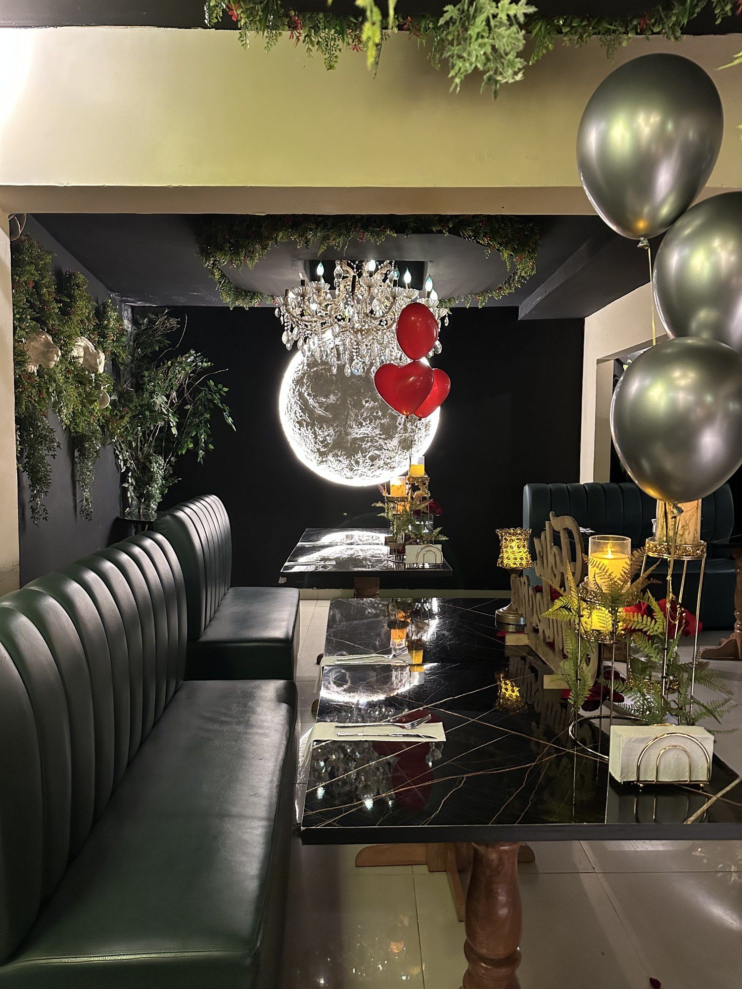 Mesa decorada con globos, rosas y velas para una celebración