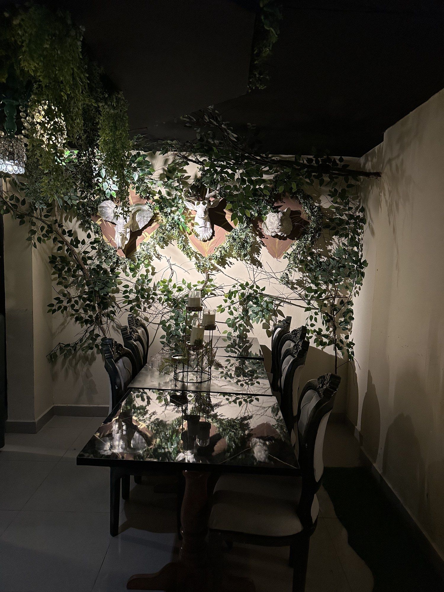 Mesa larga para grupos junto a una pared cubierta de plantas
